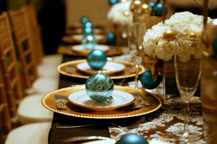 centros de mesa, flores blancas en el centro de la mesa en jarrones de vidrio, bolas en azul reluciente en los platos