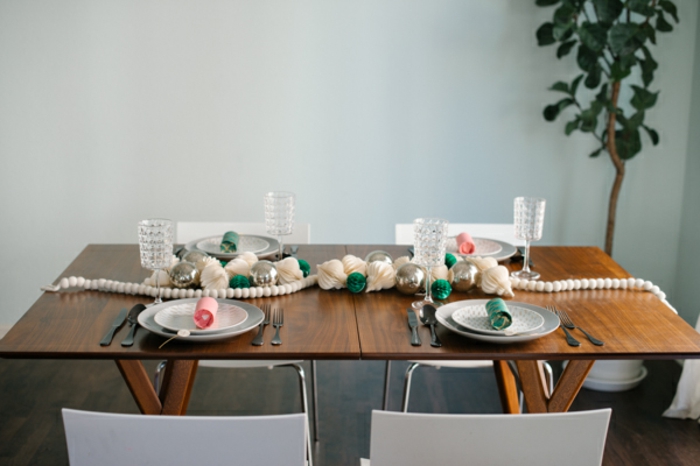 centros de mesa originales, mesa de madera simple con decoración refinada de ornamentos de papel y guirnalda de bolas pequñas