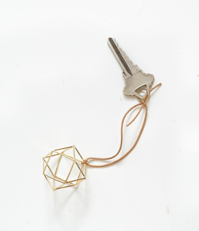 manualidades faciles, bonito porta llave con ornamento en forma geométrica, elemento dorado, llave colgado a un hilo beige
