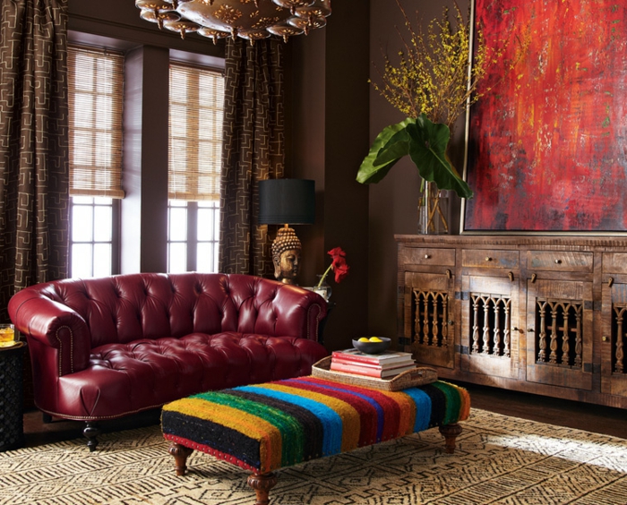 salones modernos, sofá en color bordeos, tapizado con piel en capitoné, grande pintura decorativa, banco en estilo bohemio 