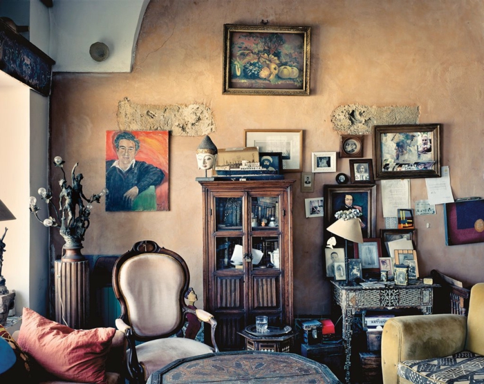 muebles de salon, salón vintage con toque bohemio, paredes en color ocre anaranjado, muchas pinturas en las paredes