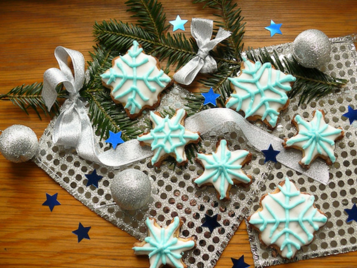 galletas de navidad, idea fresca y festiva, galletas en forma de copos de nieve, glaseado en azul claro 