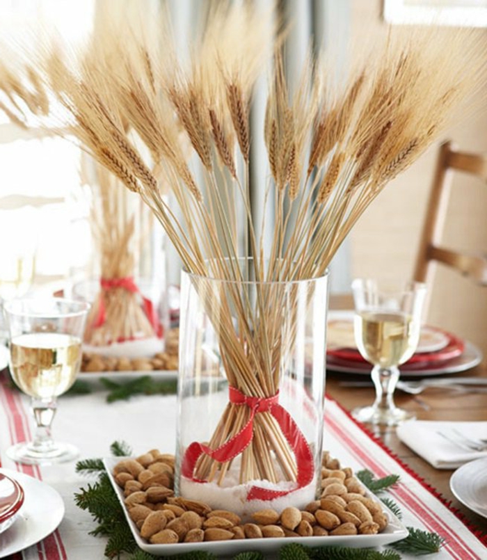 centros de mesa navideños, idea simple y económica con ramo de trigo seco y ramas de pino, cubierta en blanco con bordes en rojo 