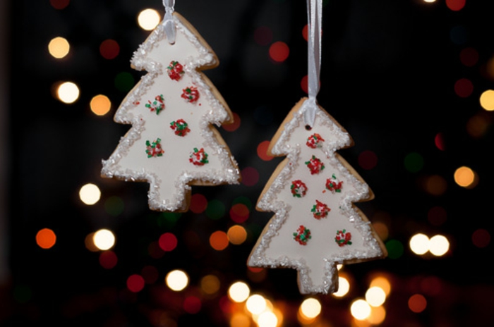 como hacer galletas de navidad, árboles blancos decorados con glaseado real, palitos de azúcar en rojo, verde y blanco 