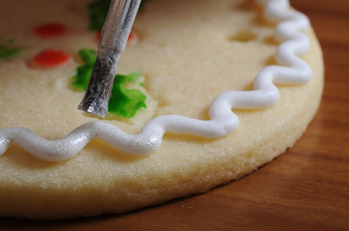 recetas de galletas faciles, como adornar una galleta con un pincel fino y glaseado real blanco 