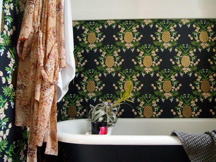 muebles de baño, baño en estilo bohemio con papel pintada con piñas en fondo negro, bañera moderna y decoración de flores
