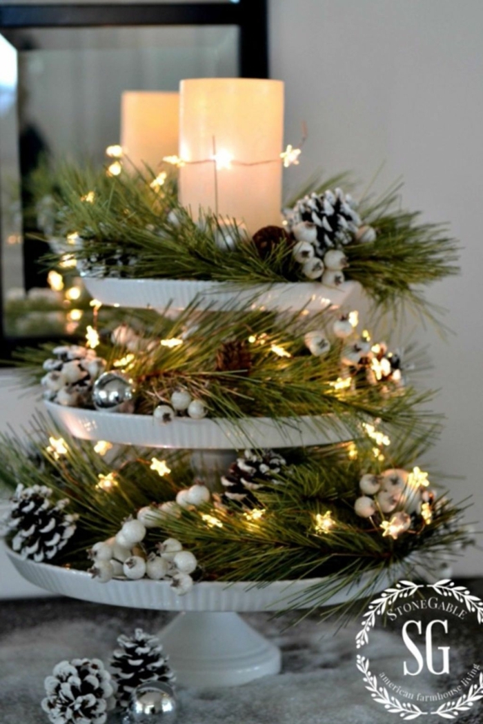 centros navideños, centro de mesa elegante hecho de materiales naturales, piñas pintadas en blanco con efecto de nevado, grandes velas y bombillas en forma de estrellas