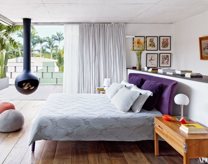 dormitorios de matrimonio, ideas de decoración de dormitorios 2018, cama tapizada de terciopelo en color lila, chimenea de leña colgante, suelo de madera