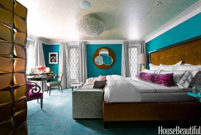 dormitorios de matrimonio, grande habitación en color ocre y aguamarina, cama tapizada en terciopelo en capitoné, suelo de moqueta en azul