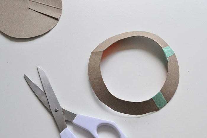 manualidades creativas, cómo decorar una caja de metal con cartón, círculo de cartón y tijeras
