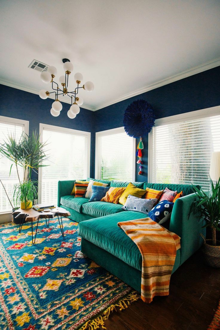muebles de salon, salón moderno en colores saturados, alfombra vintage, sofá tapizada en terciopelo verde, lámpara de araña blanca