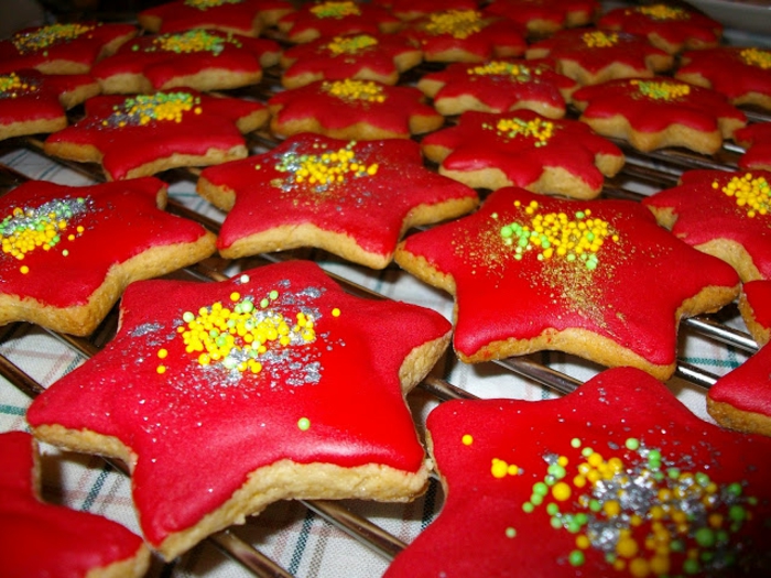 galletas de mantequilla receta, estrellas de navidad decoradas en rojo con bolitas de azúcar en amarillo y verde