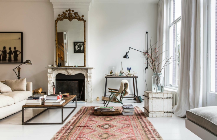 salon, ambiente en blanco con alfombra en colores cálidos, espejo vintage y chimenea de leña