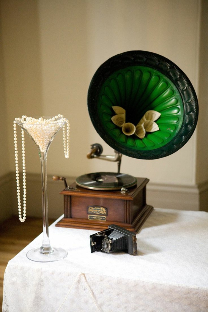 decoracion vintage, gramófono vintage en verde, decoración de collar de perlas puesto en vaso de cristal alto, paredes en beige