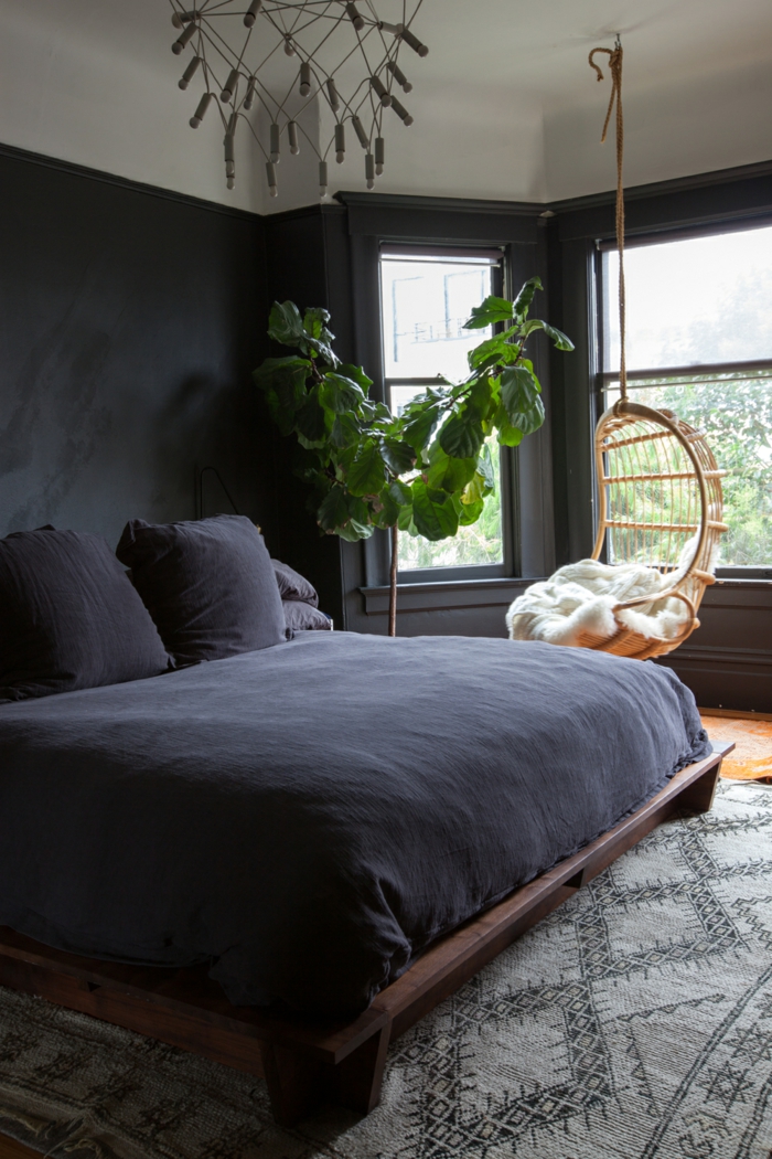 dormitorios modernos, dormitorio acogedor en colores oscuros, plantas decorativas, silla colgante de mimbre 