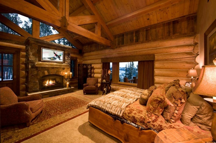 cabañas con encanto, dormitorio acogedor en colores calientes techo con vigas de madera, cama doble con muchas almohadas y cojines decorativos