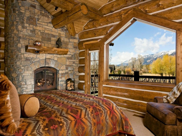 cabaña de madera, dormitorio de encanto con interesantes elementos arquitectónicos, chimenea de leña en una pared de piedra, techo de madera