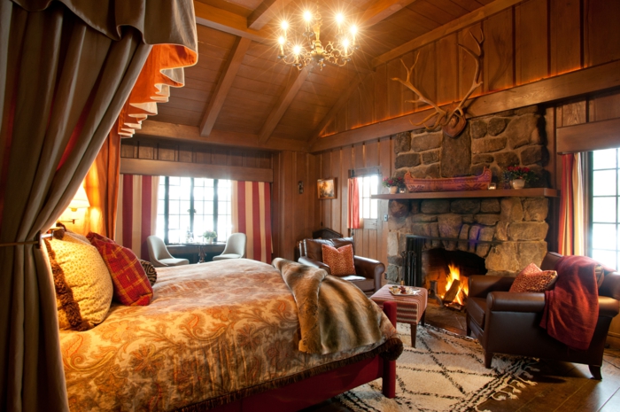 cabañas con encanto, habitación en colores cálidos, grande chimenea de leña, techo y paredes de madera