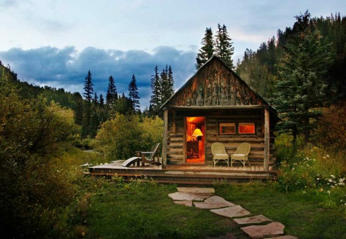 cabaña de madera, cabaña rural hecha de madera, veranda con sillas, sendero de piedras, prado en el bosque 