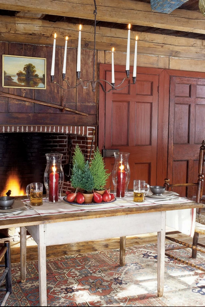 centro de mesa, decoración con pinos pequeños y peras, salón en estilo rústico, centro de mesa con grandes velas rojas y materiales naturales