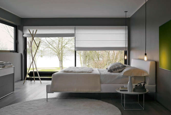 dormitorio matrimonio, bonita habitación en blanco y gris con detalle en verde, alfombra oval en blanco, suelo de madera