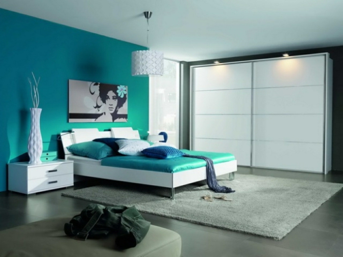 dormitorio matrimonio, grande habitación decorada en color turquesa, punto focal en la pared, suelo en gris y alfombra en beige