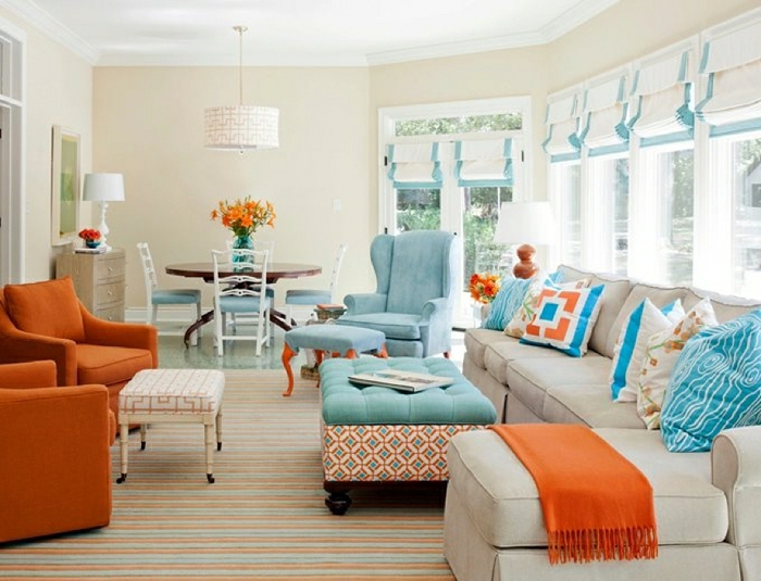 salones modernos, grande salón en blanco, anaranjado y azul, sillones tapizados en terciopelo en azul celeste, grandes ventanales 