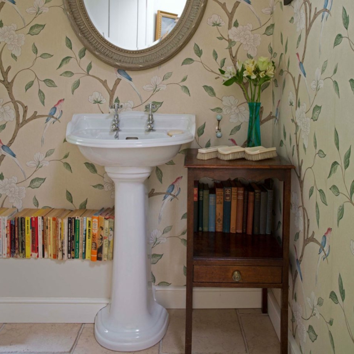 baños modernos, baño ecléctico con estantería de libros, armario vintage de madera y papel pintado con estampado de flores
