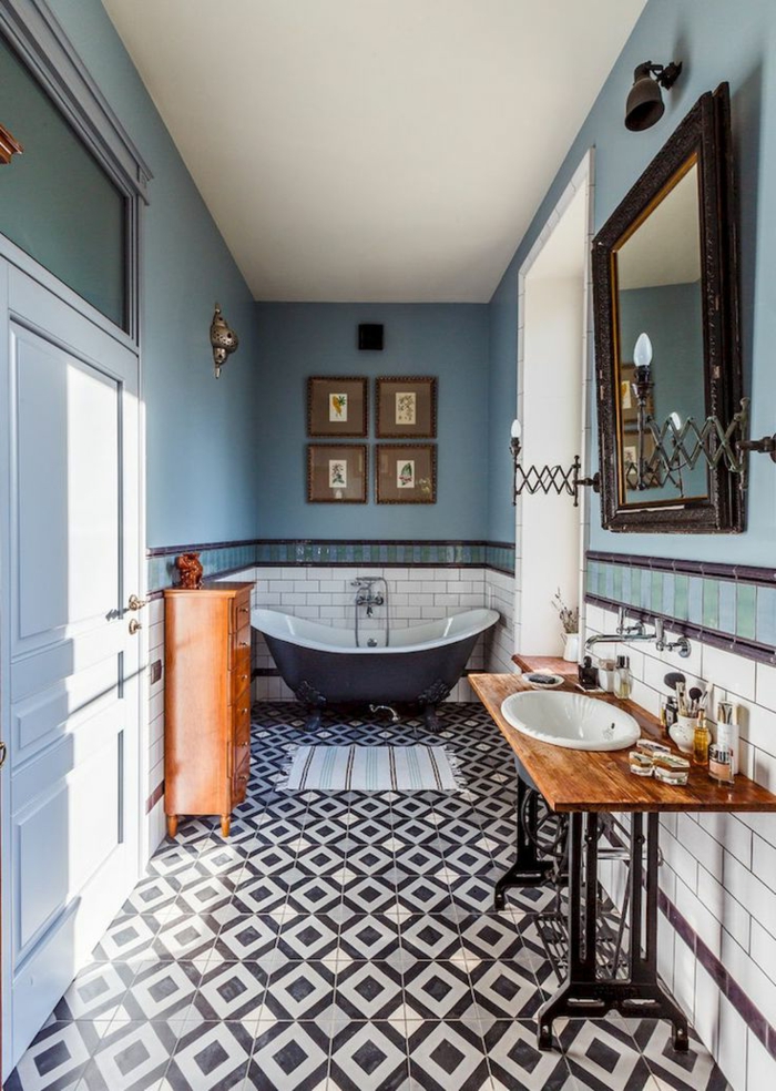 laminas decorativas,baño largo y estrecho, paredes en blanco y azul, espejo grande, bañera. cuadro cuadros pequeños con marcos de madera