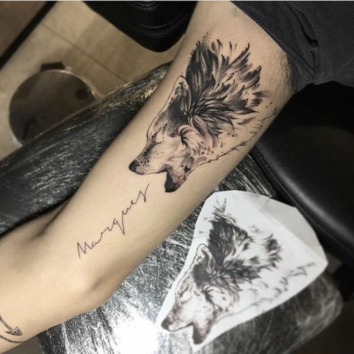 dibujos de lobos, tatuaje en el barzo hombre, lobo aullando y nombre en cursiva, tatuaje en blanco y negro
