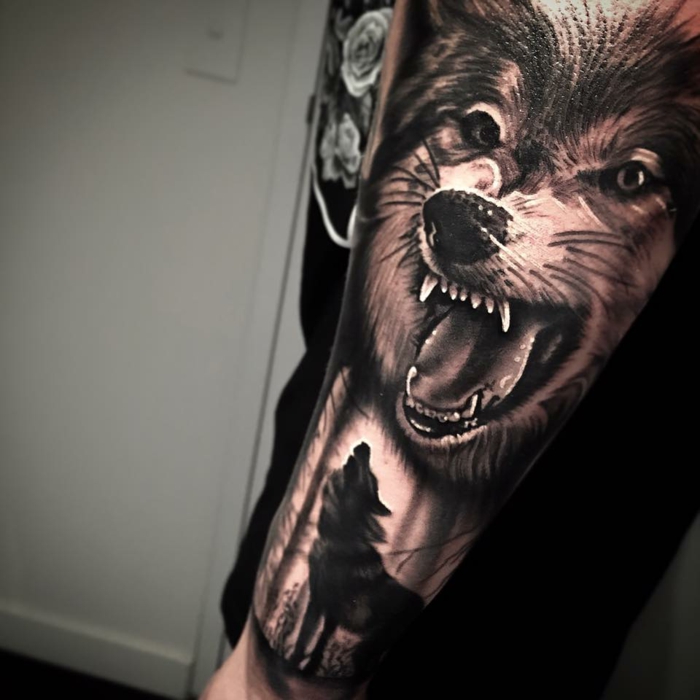 dibujos de lobos, tatuaje expresivo para hombres, tatuaje brazo con lobo atacando y otro lobo aullando en segundo plano