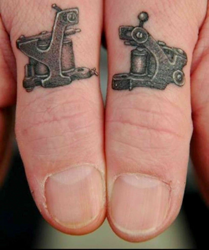 tatuajes en la mano, manos de hombre con tatuajes de máquinas antiguas negras en los dos pulgares