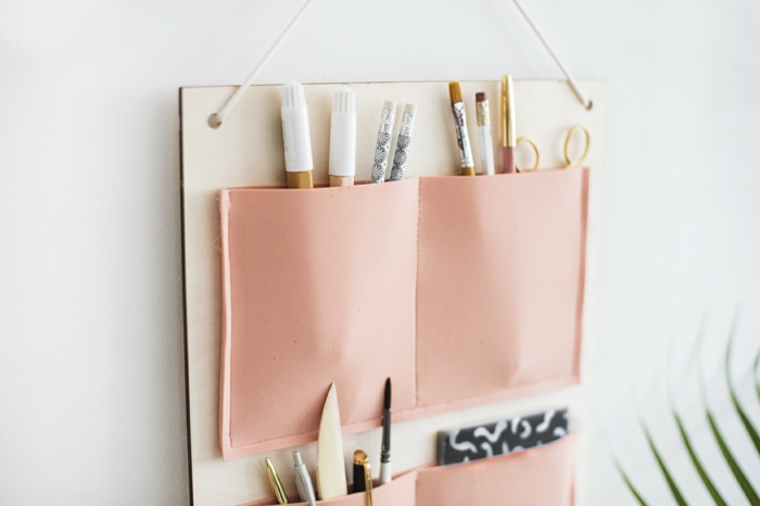 manualidades sencillas, ideas DIY originales, bolsillos en rosado pegados a un tablero de madera colgado en la pared