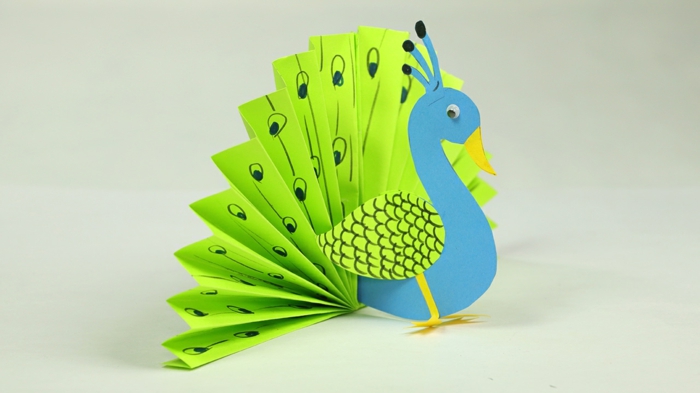 manualidades paso a paso, figurita de pavo real en azul y verde, manualidad origami fácil apta para niños