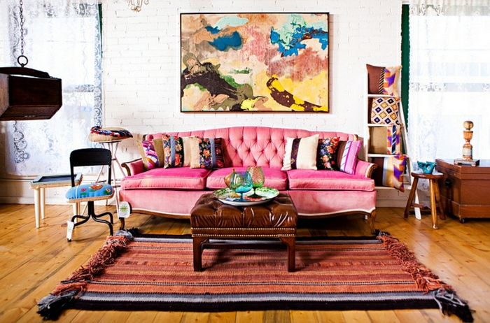 como decorar un salon, interior moderno con sofá en capitoné color fucsia, pintura bonita, suelo de parquet y alfombra en boho chic