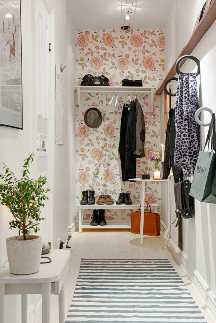 muebles de entrada, recibidor en el pasillo, papel pintado con flores grandes, ganchos como grandes anillos, estantes de zapatos, tapete rayado
