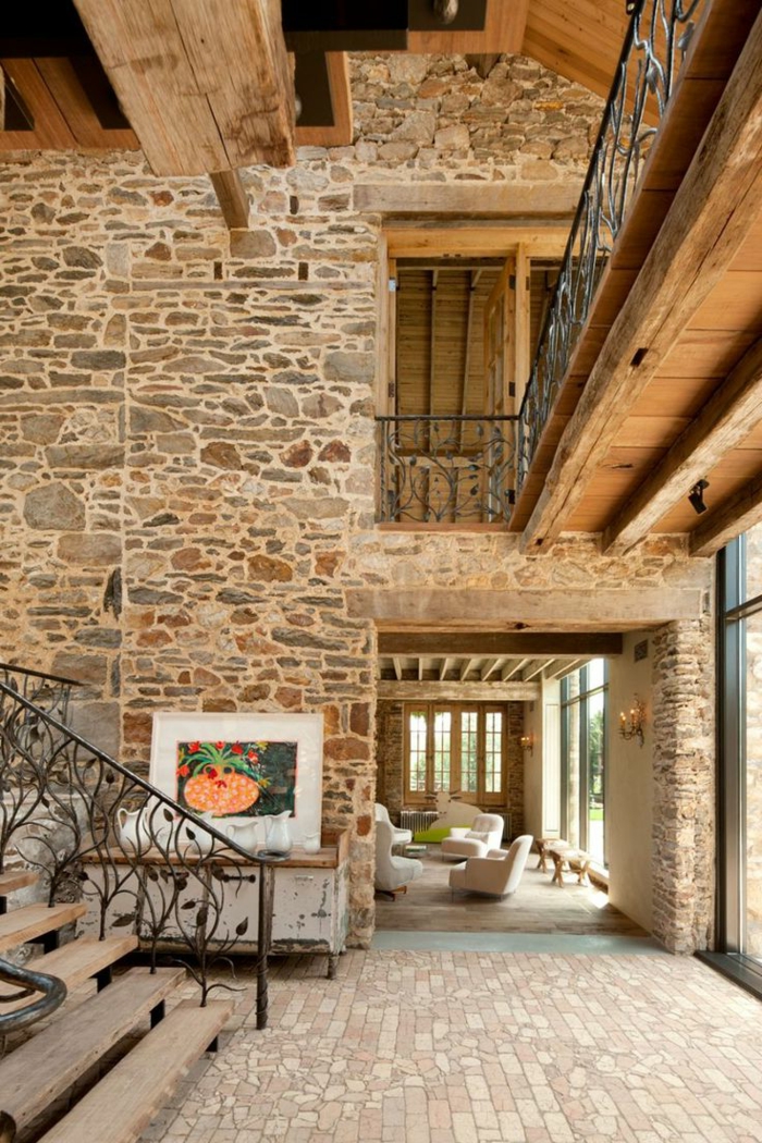 paredes decoradas, casa en estilo rústico de dos plantas, escaleras de madera, techos altos y paredes de piedra