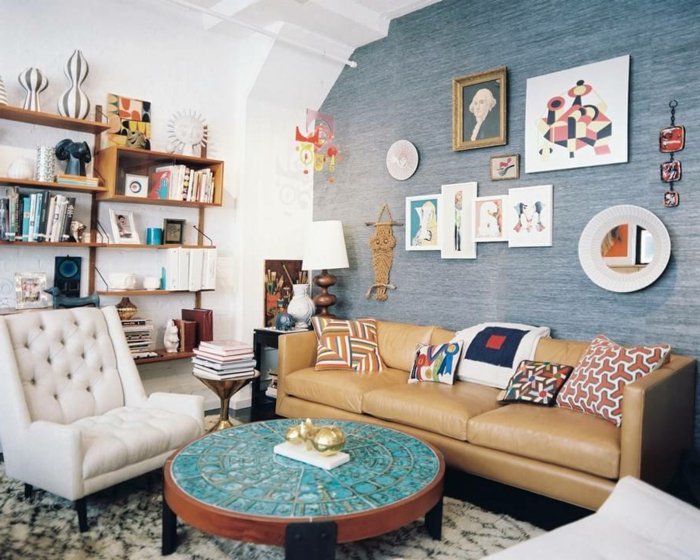 habitacion vintage, paredes con mucha decoracion original, muebles vintage, sillón en capitoné, y sofá en beige