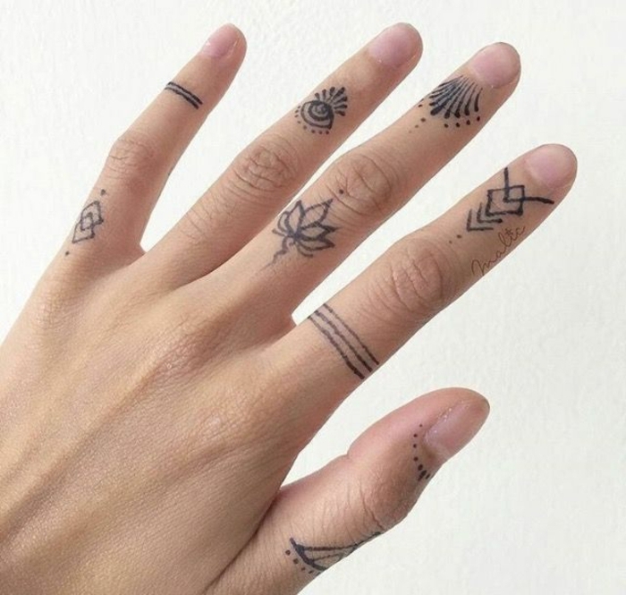 tatuajes en la muñeca, mano de mujer, diferente tatuaje en cada dedo, el ojo de la providencia, motivos florales, tatuaje de anillo