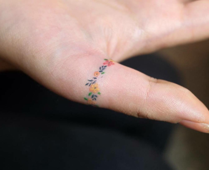 tatuajes en la mano, tatuaje minimalista femenino para mujeres, anillo de flores de color en el pulgar