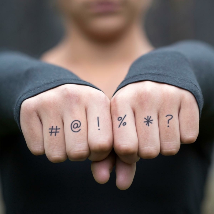 tatuajes cotazon, mujer con mangas largas, tatuajes en los dedos con signos de la puntuación y de teclado de ordenador