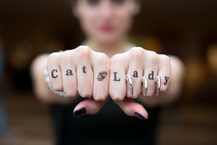 tatuajes en los dedos, idea de tatuaje para mujer con frase y diamante en los dedos, anillos como uñas de gato