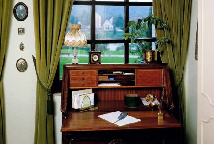 habitacion vintage, escritorio de madera viejo, cortinas en verde de terciopelo, objetos vintage