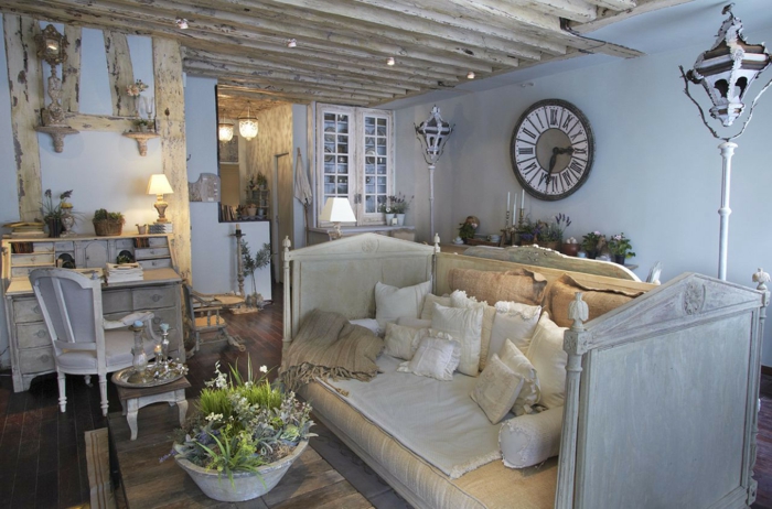 salones vintage, interior en azul claro con vigas de madera y mueble s con efecto envejecido, cama con cabecero vintage