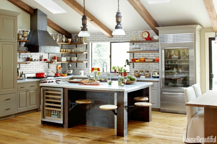 cocina en blanco con grande barra en la mitad, diseño de cocinas funcionales y bonitas, techo con vigas de madera y suelo de parquet