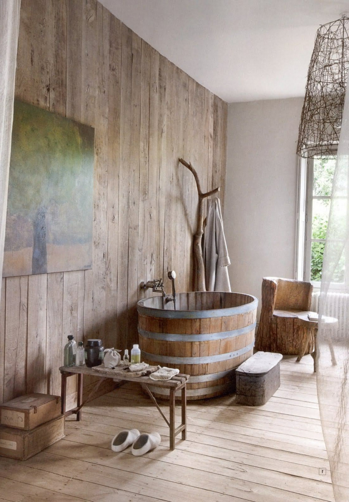 ideas de diseño de baños rusticos, revestimiento entero de madera, pintura decorativa en la pared y una bañera de madera en estilo vintage 