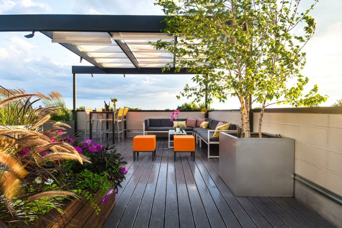 ideas coloridas para terrazas con encanto, pequeñas sillas en anaranjado, detalles en amarillo, pergola moderna y muchas plantas verdes