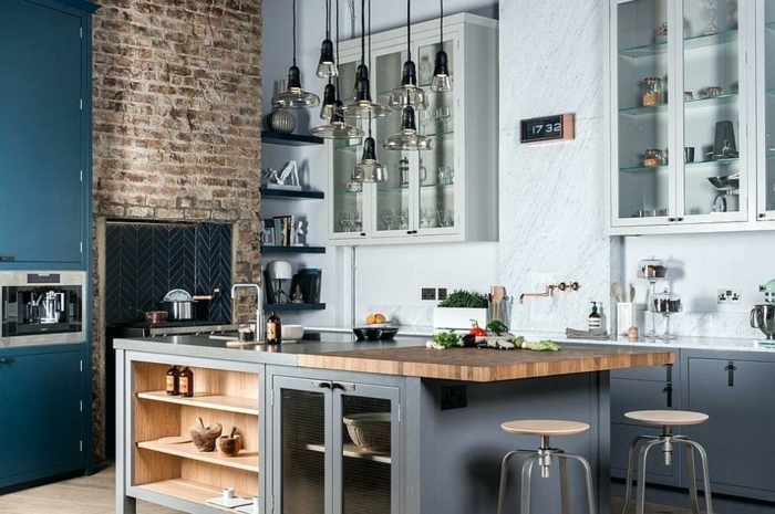 cocina moderna con detalles en azul, muebles de cocina de madera pintadas en azul y gris, pared de ladrillos