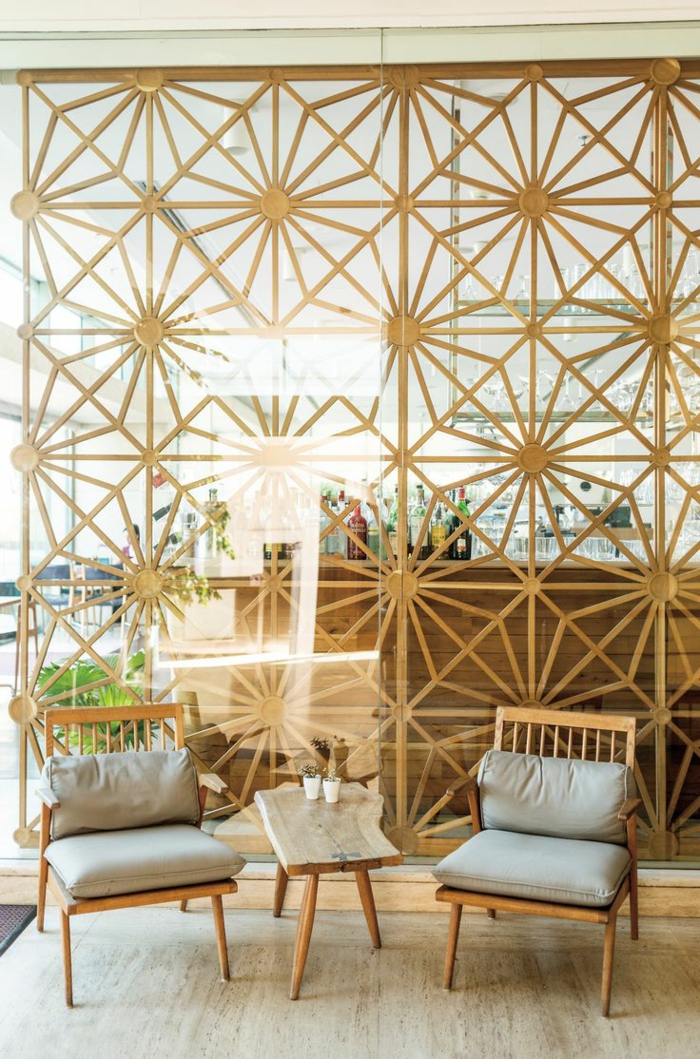 separadores de ambientes, salón en beige con separador de ambientes en rejilla de madera con ornamentos, mesa y sillas de madera