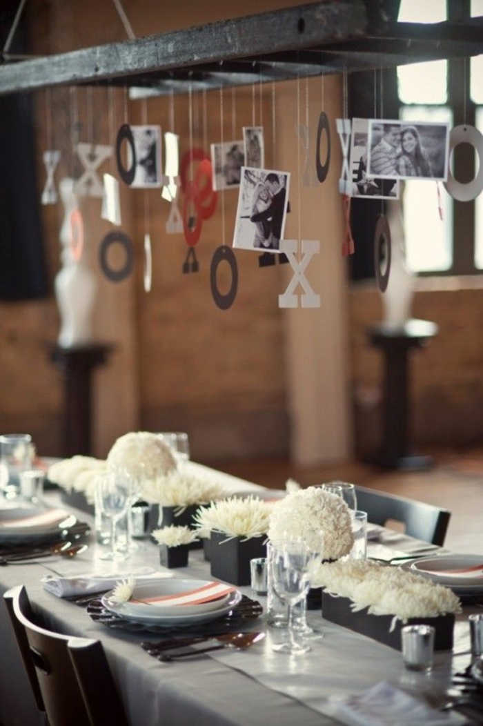 fotos originales, centro de mesa colgante original, viga de madera con pequeñas fotos colgantes, flores blancas para decorar la mesa
